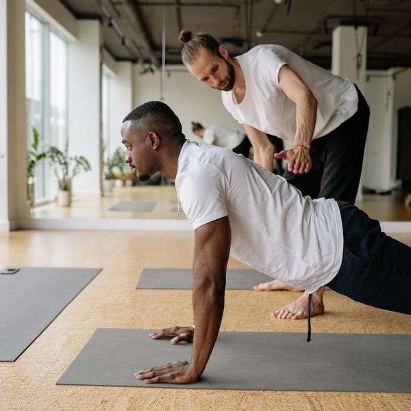 A focused man doing a core-strengthening plank exercise on a mat.